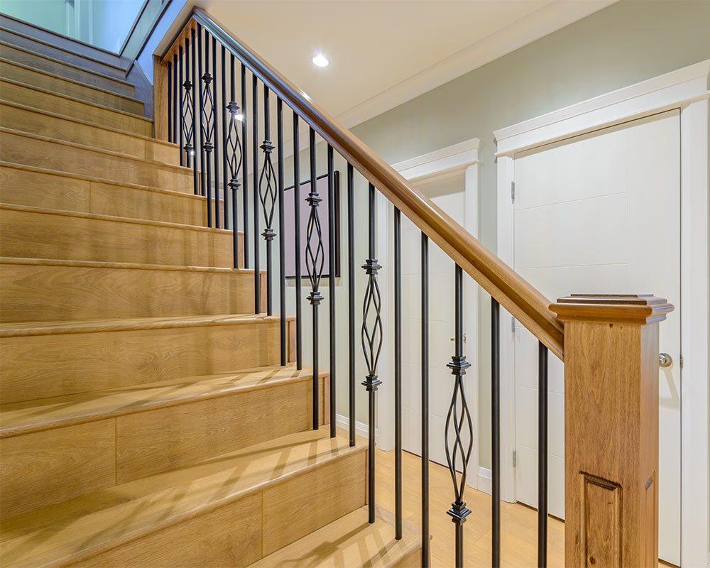 light wooden staircase with black metal decorated railing round rock tx