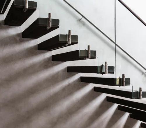 black steps and glass side of floating stairs